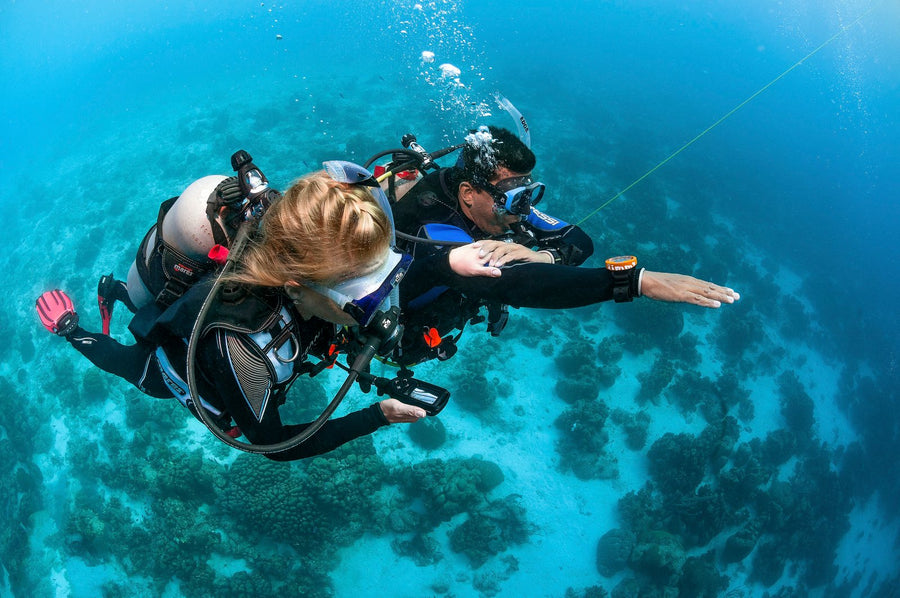 Diver navigating underwater with a compass
