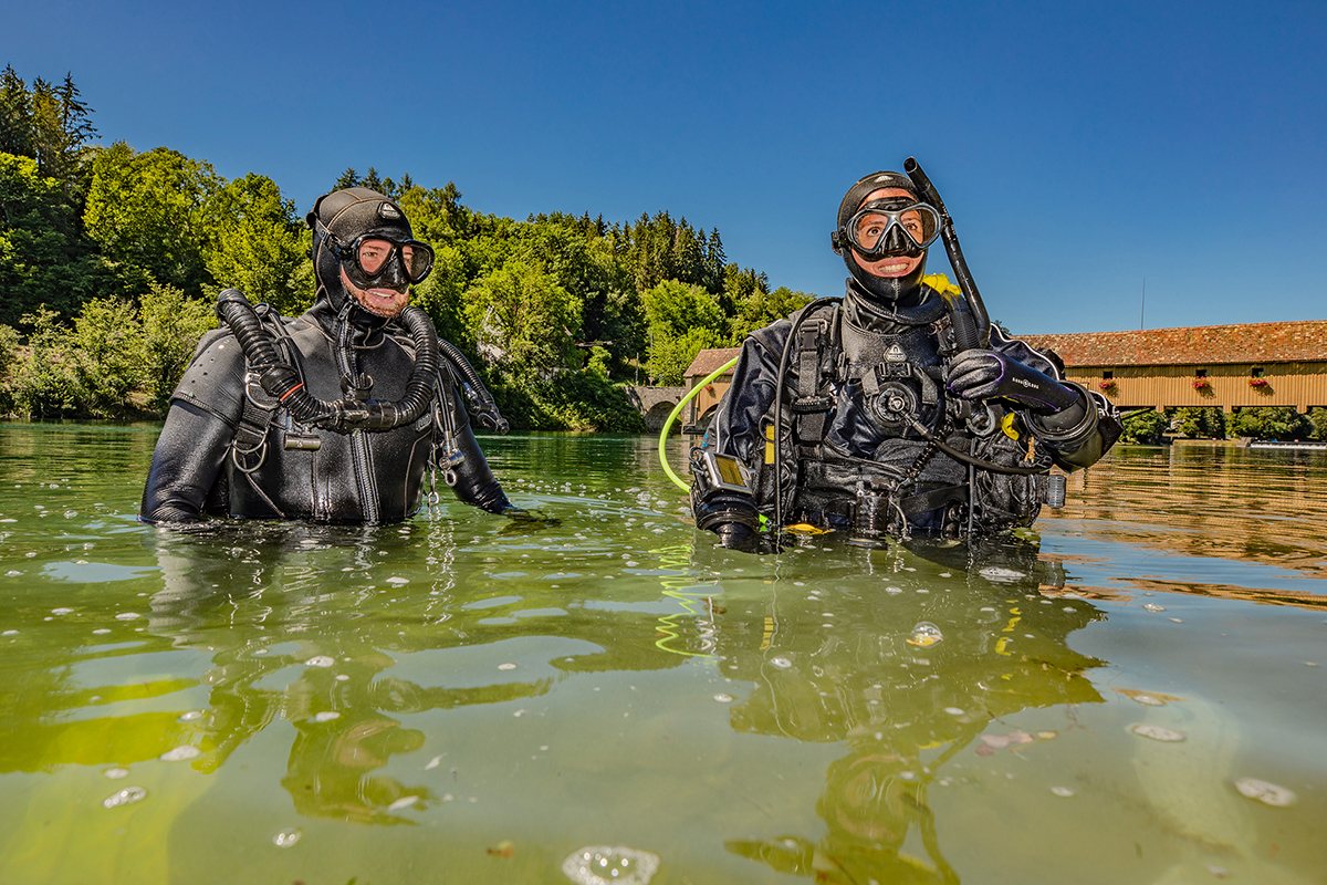 Two divers smiling at the surface of a quarry lake